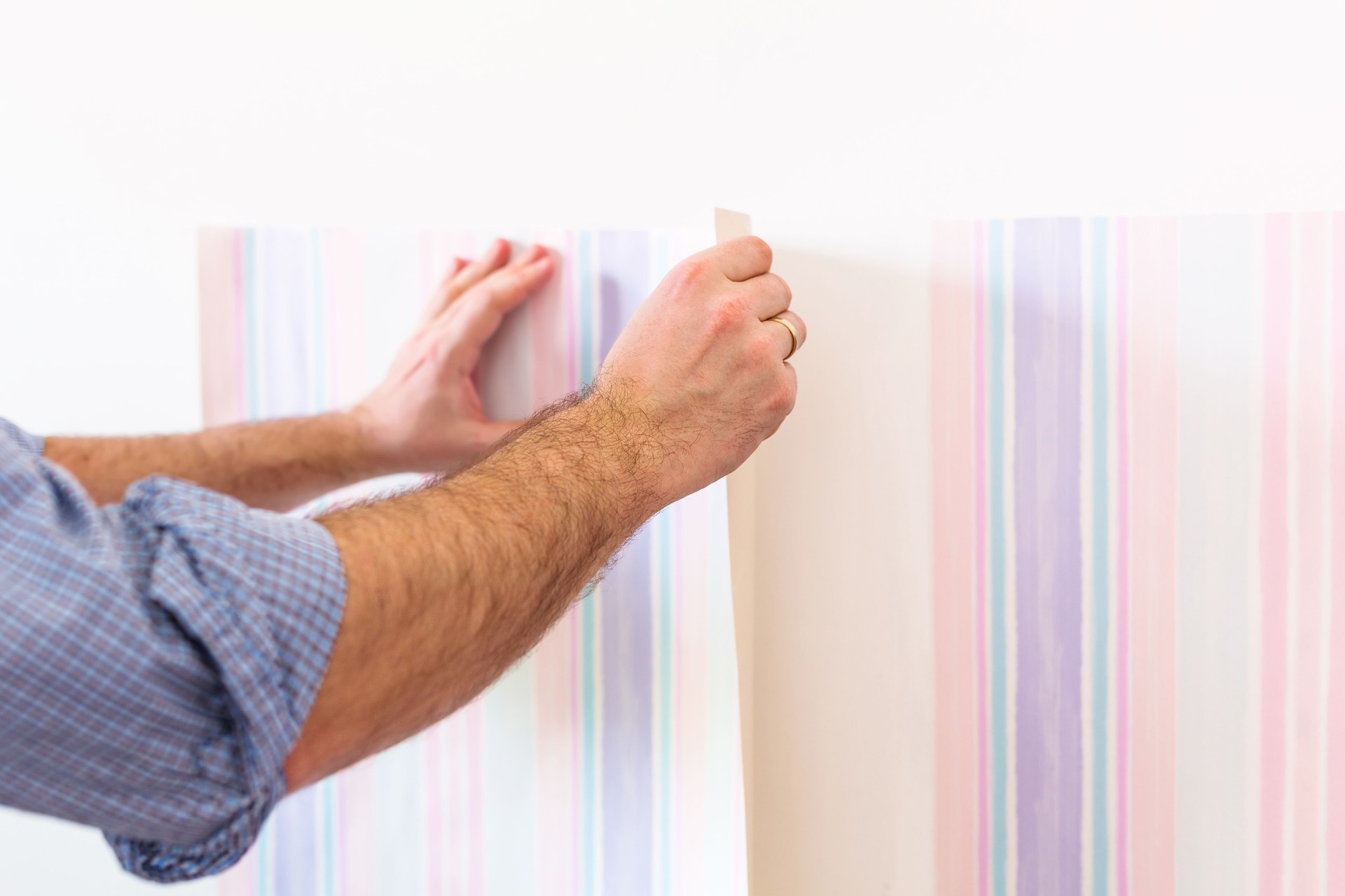 Handyman putting up wallpaper